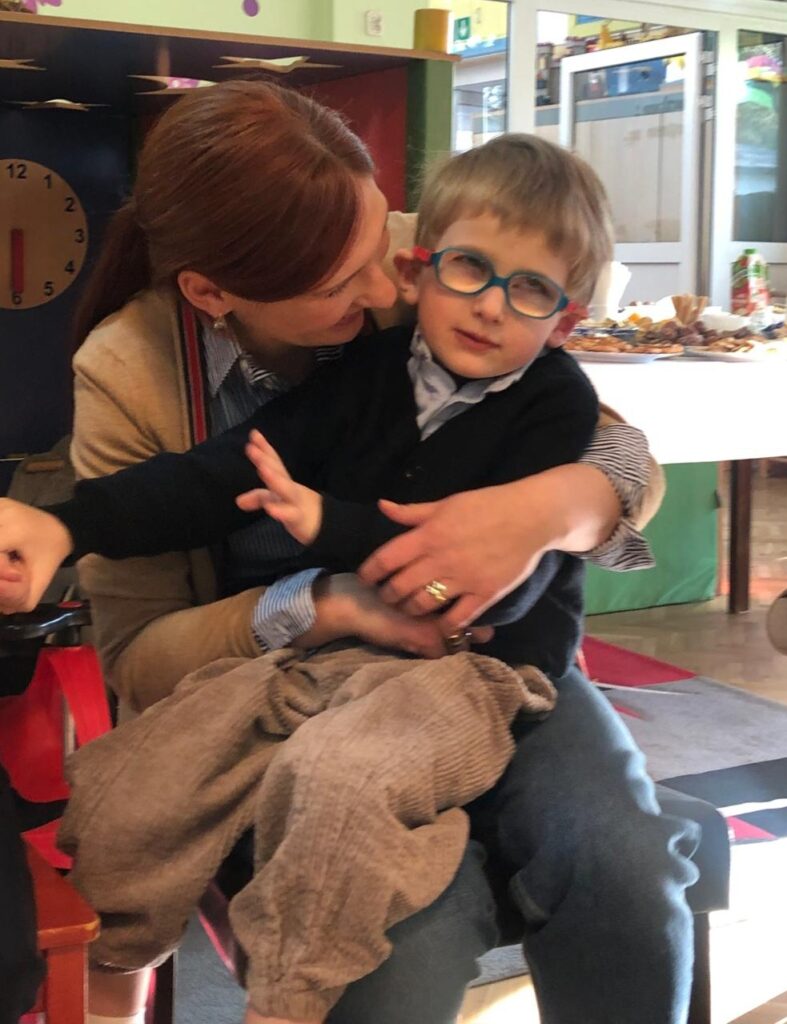 Mama trzymająca synka na kolanach
