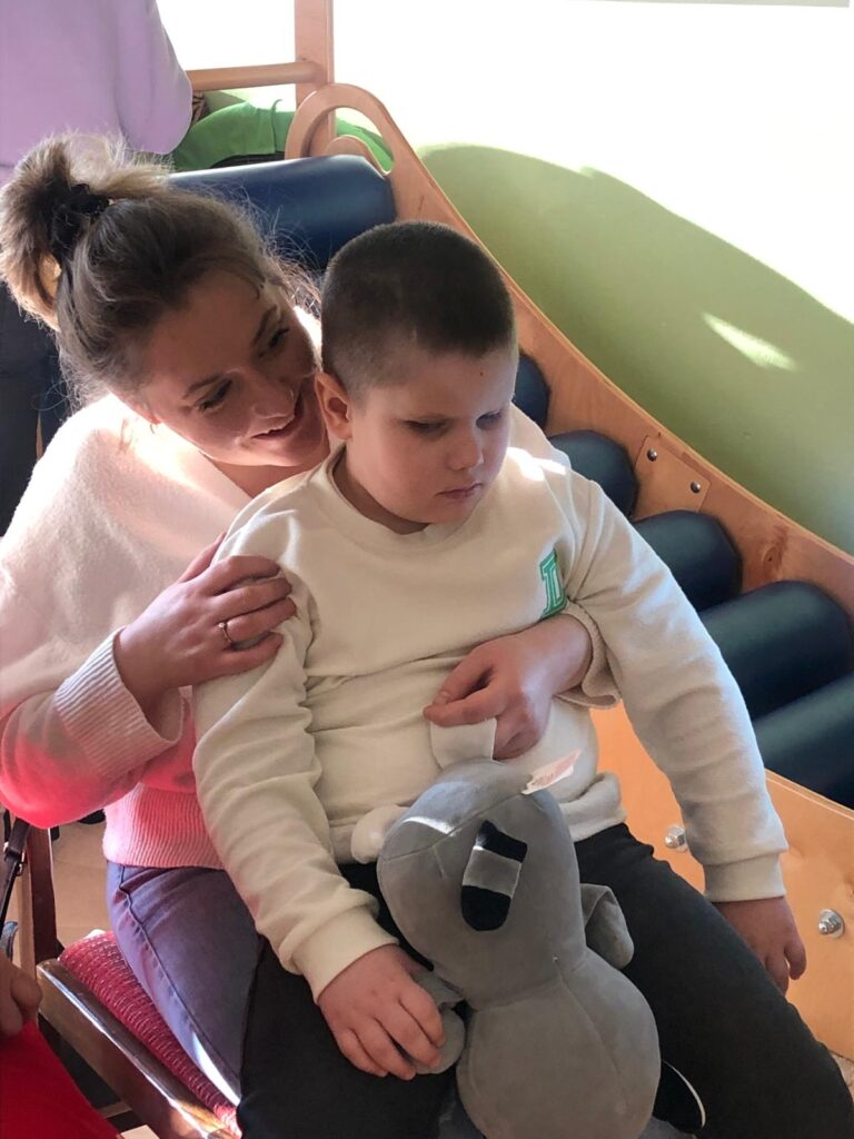 uśmiechnięta mama z synkiem na kolanach