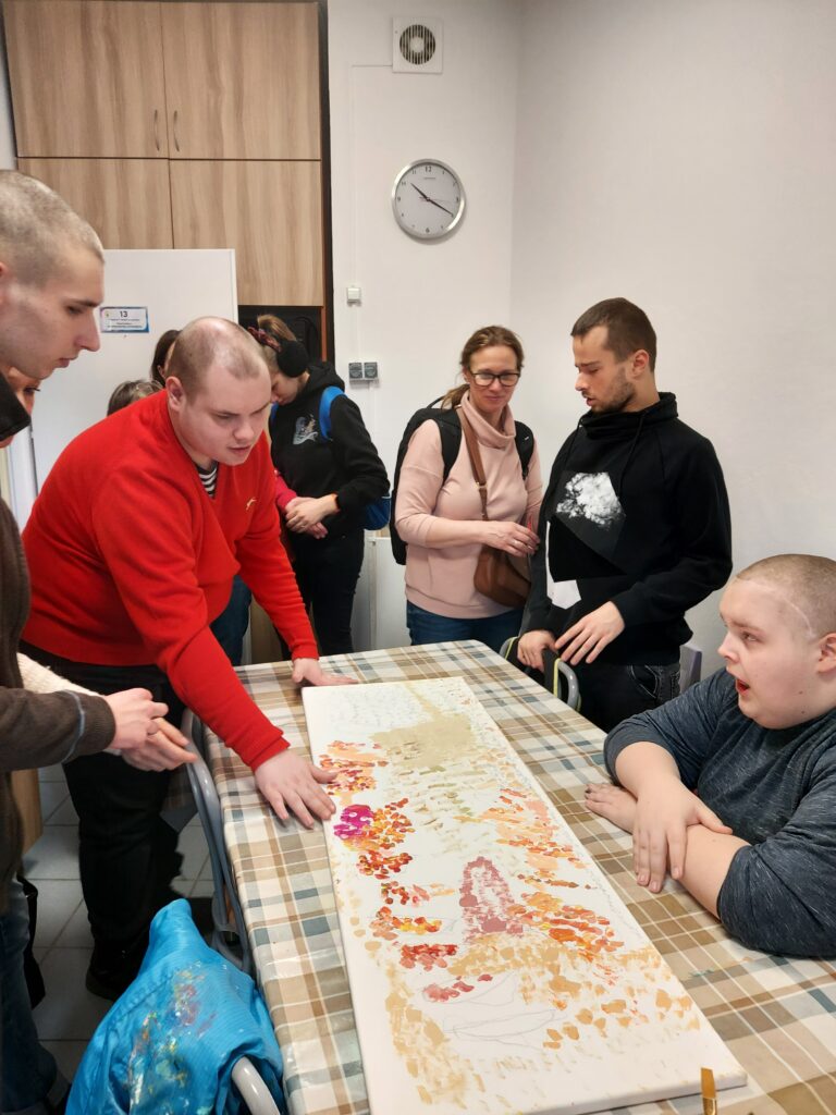 Chłopcy oglądają obraz namalowany farbami