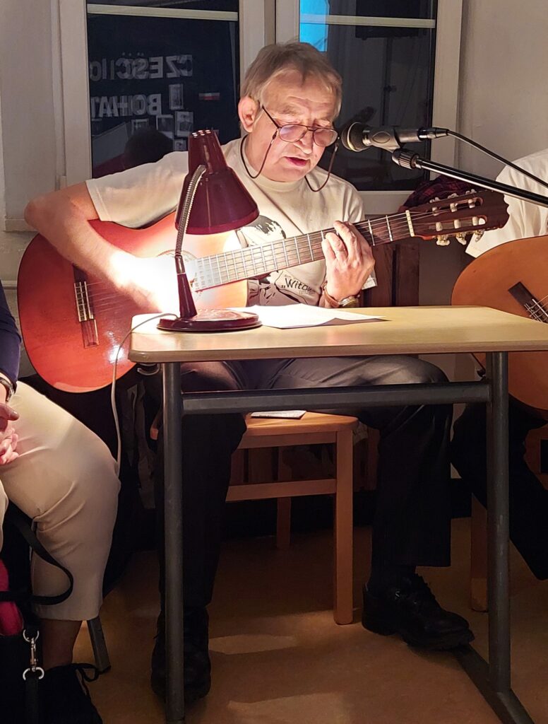 Pan Zbyszek gra na gitarze i śpiewa