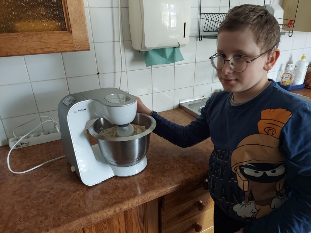Bartek włącza mikser, by wymieszał składniki ciasta