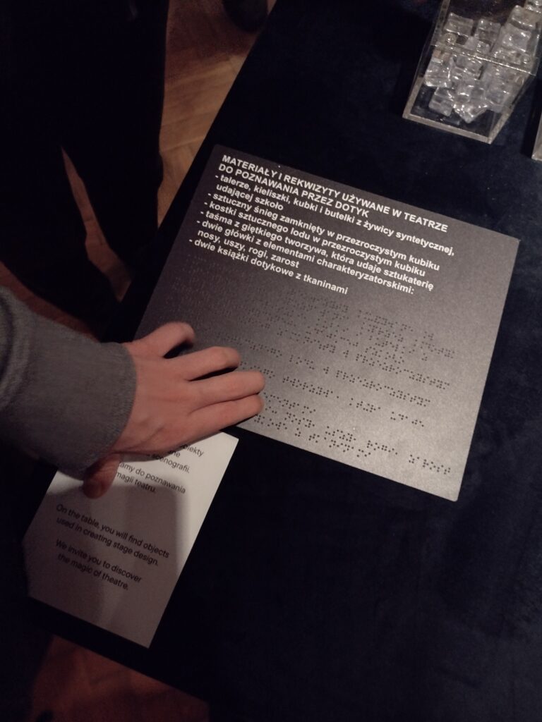 Uczeń czyta tekst brajla związany z rekwizytami w teatrze.