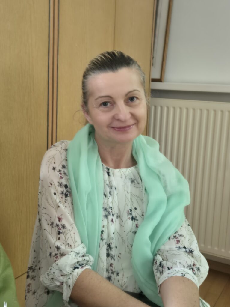 Pani Aneta ma na szyi zieloną apaszkę