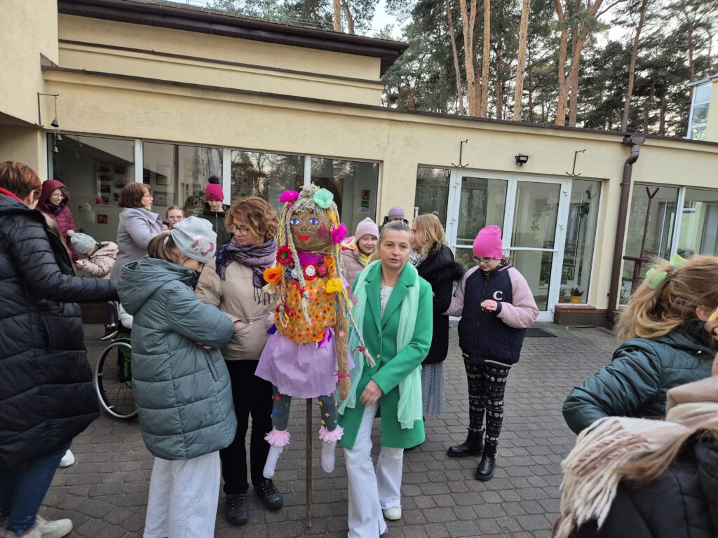 Tuż przed Internatem uczestnicy gromadzą się a Pani Aneta trzyma Marzannę.