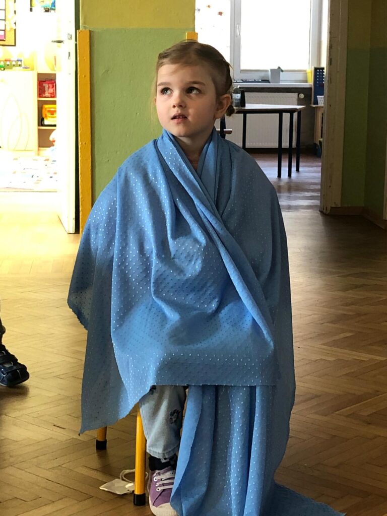 Dziewczynka okryta niebieską chustą 