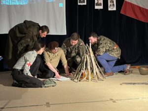 Wychowawcy jako żołnierze pochyleni nad mapą