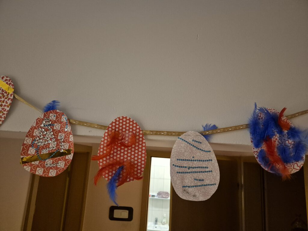Kolorowe pisanki na sznurku nad wejściem 