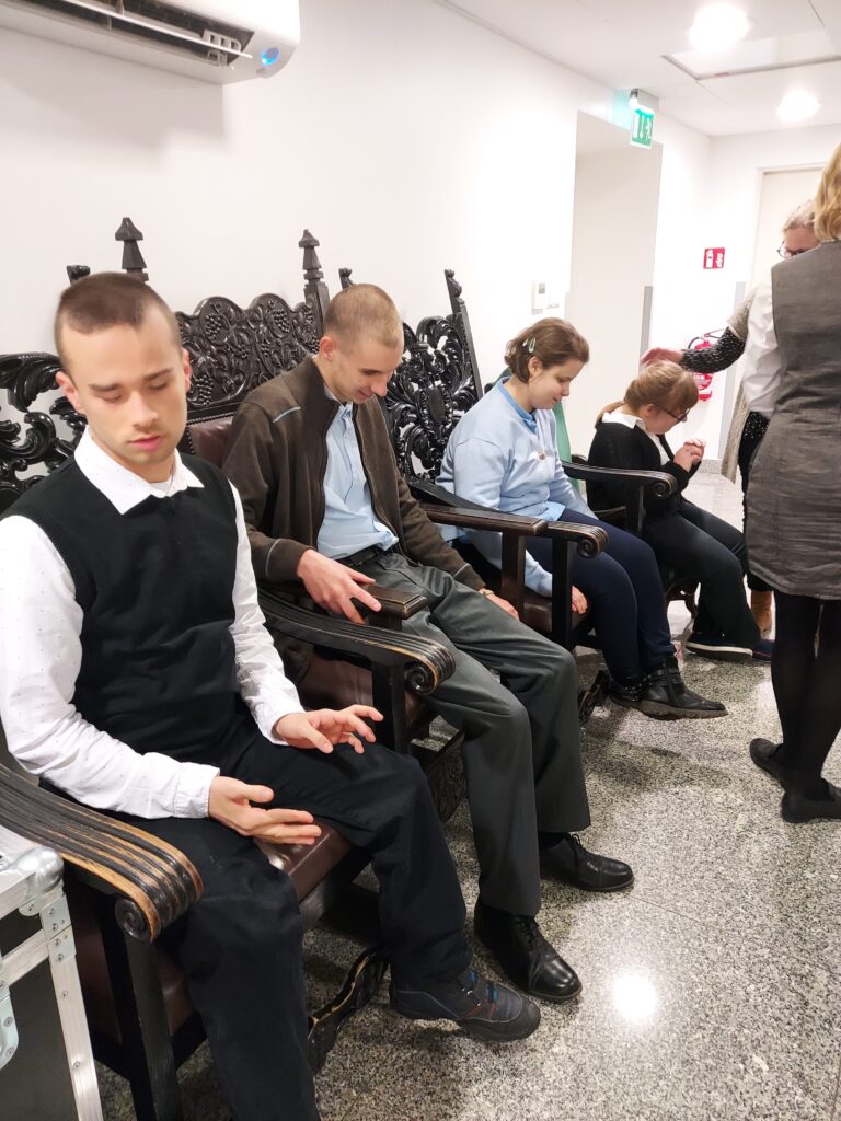 Uczniowie siedzą na krzesłach
