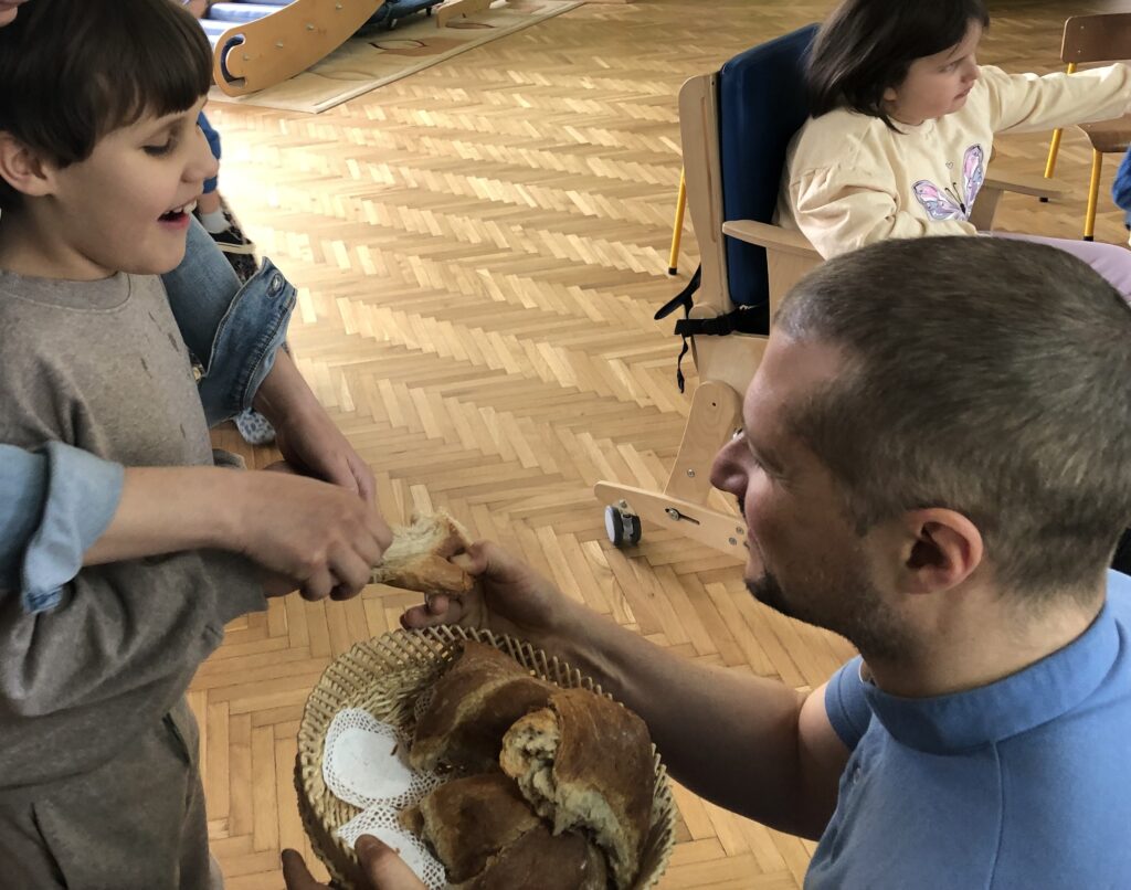 Ksiądz dzieli się chlebem z chłopcem.