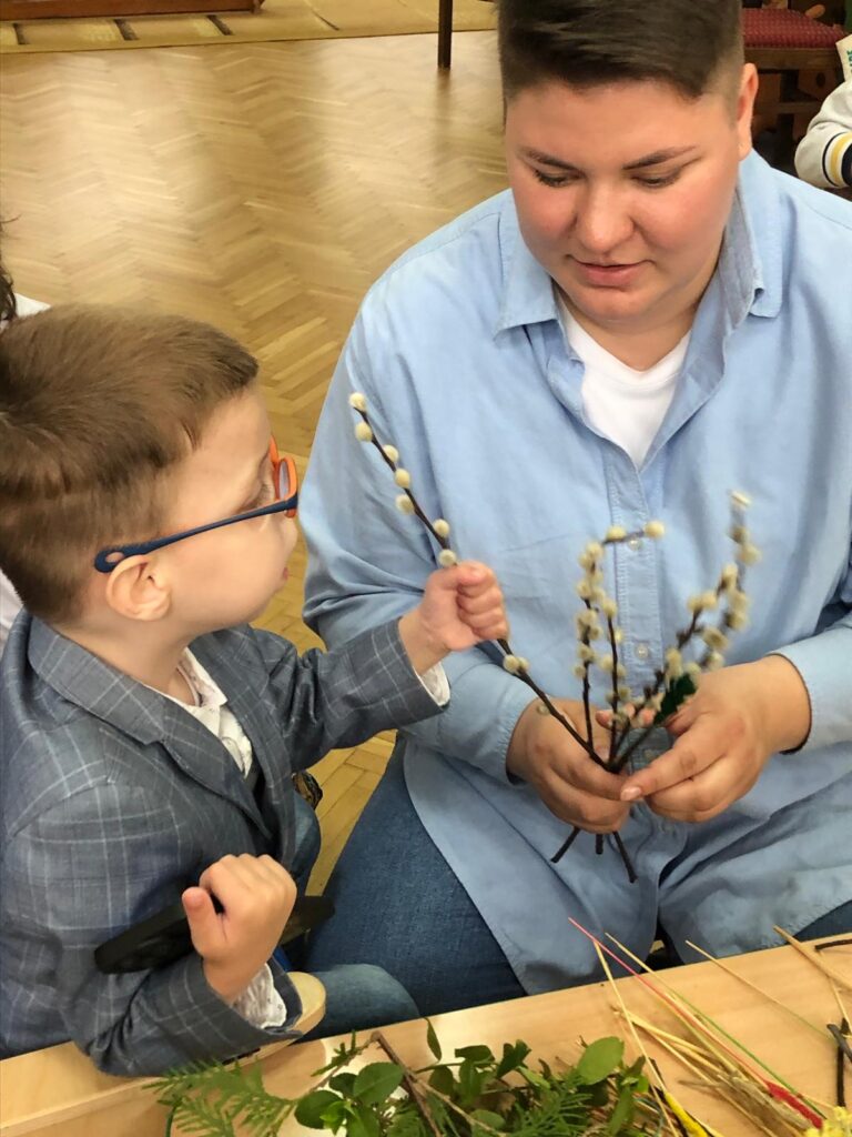 Mama pokazuje synkowi gałązki bazi.