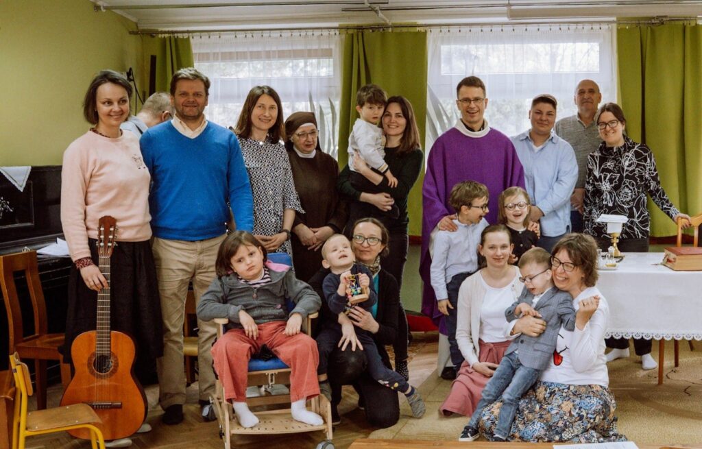 Zdjęcie grupowe rodziców, nauczycieli i dzieci z księdzem Markiem.