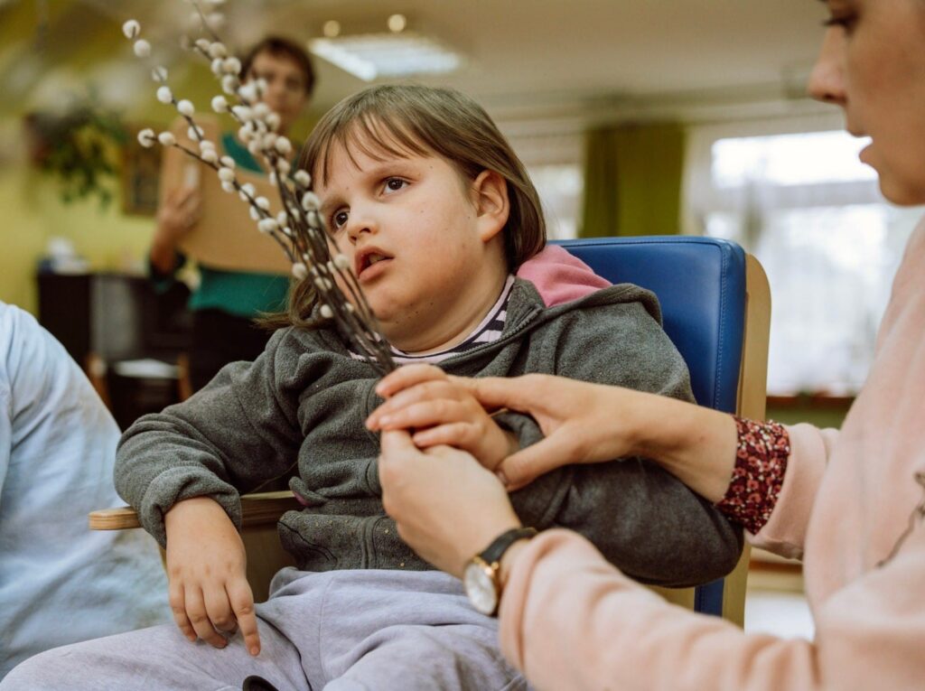 Mama pokazuje córce gałązki bazi. 