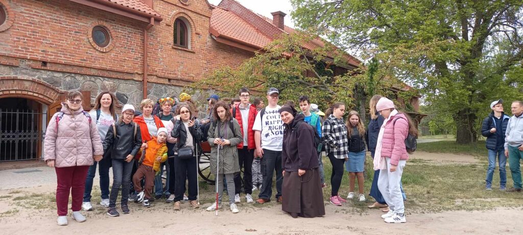 Wszyscy uczestnicy wycieczki na tle powozowni