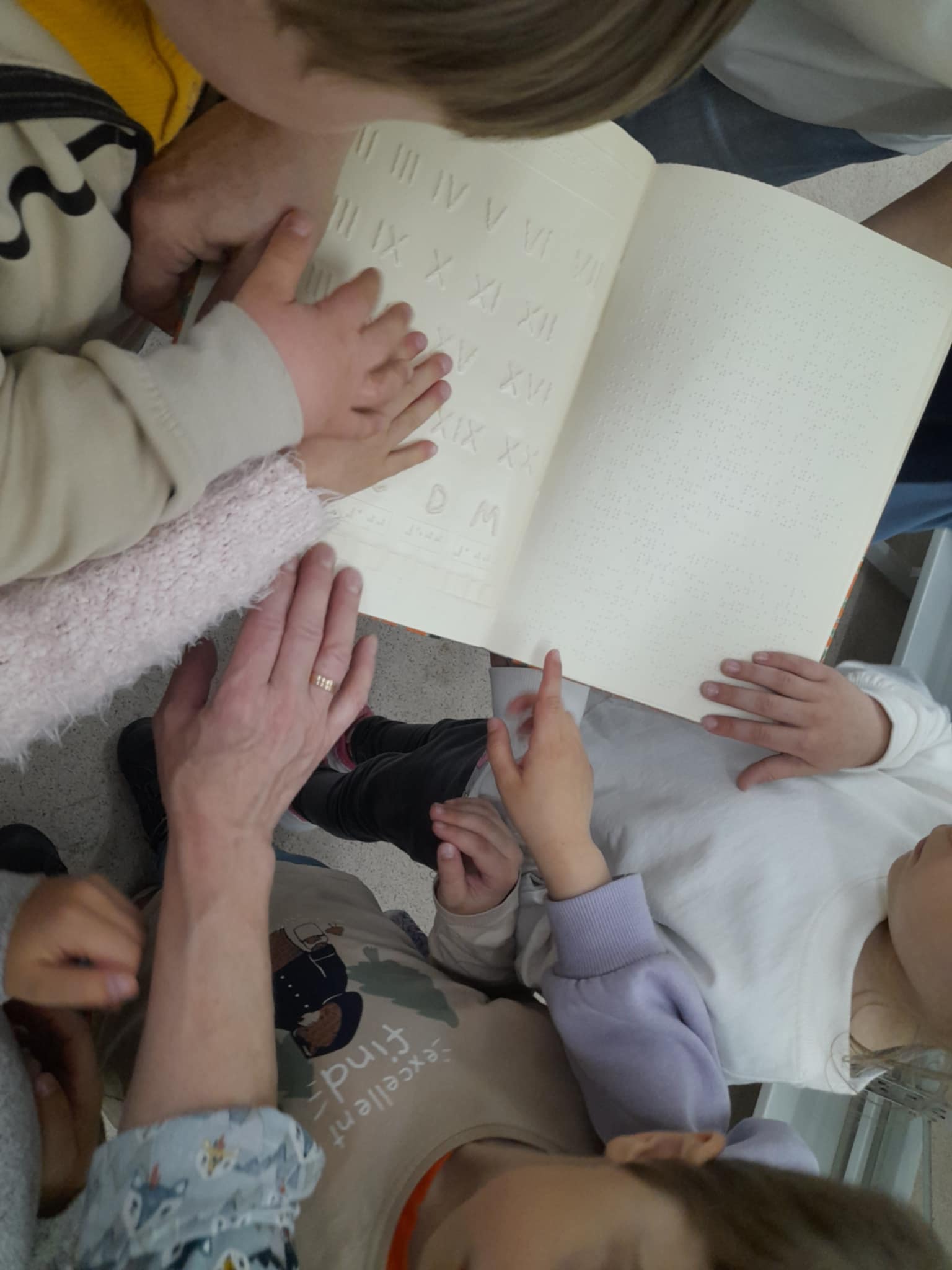 dzieci oglądające grafiki brajlowskie