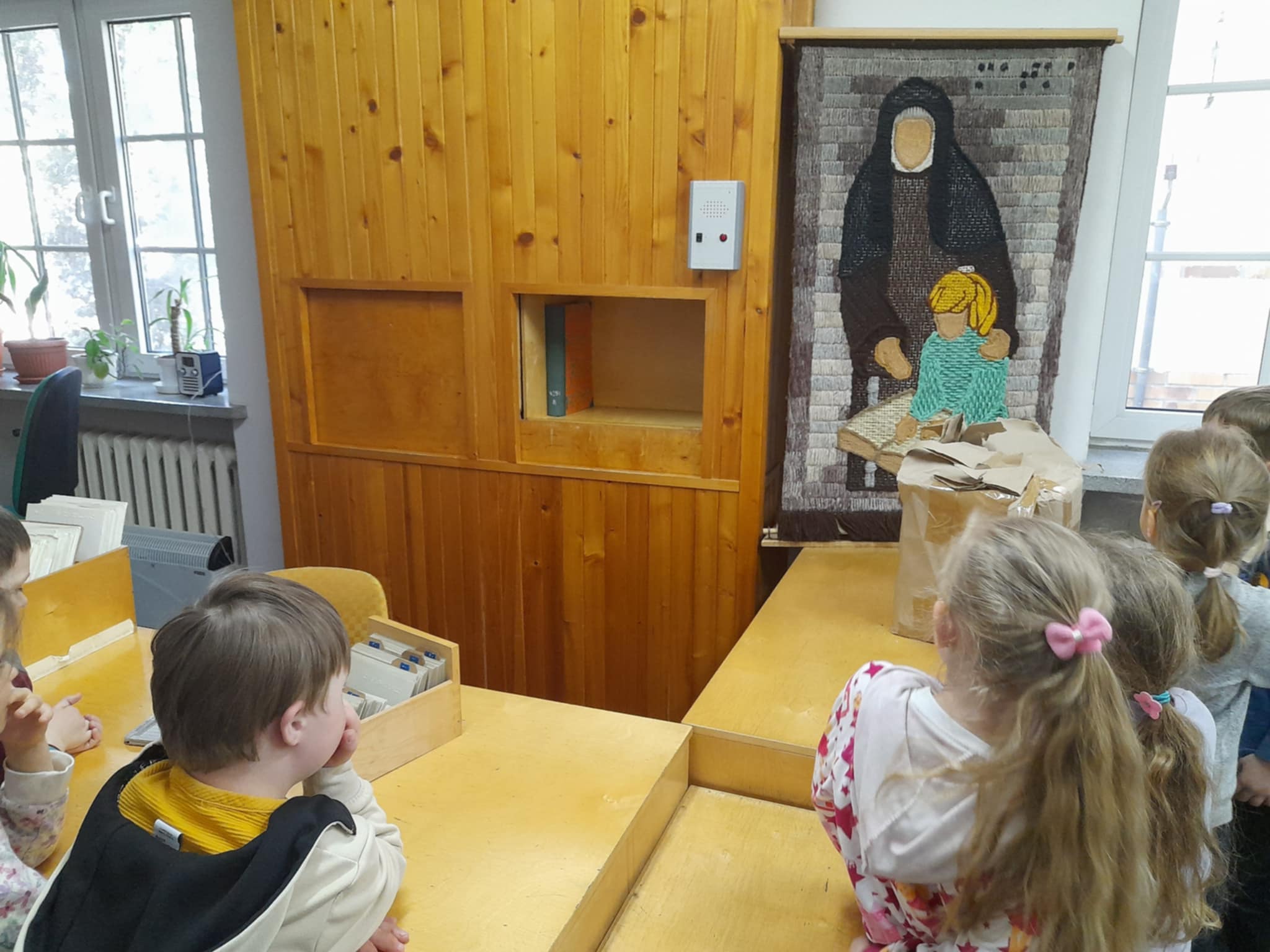 dzieci przy windzie na książki w bibliotece brajlowskiej