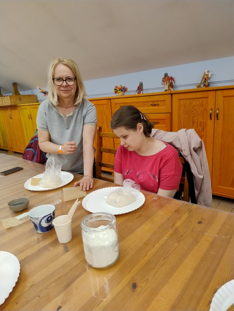 Konstancja z panią Beatą przygotowują bułeczkę