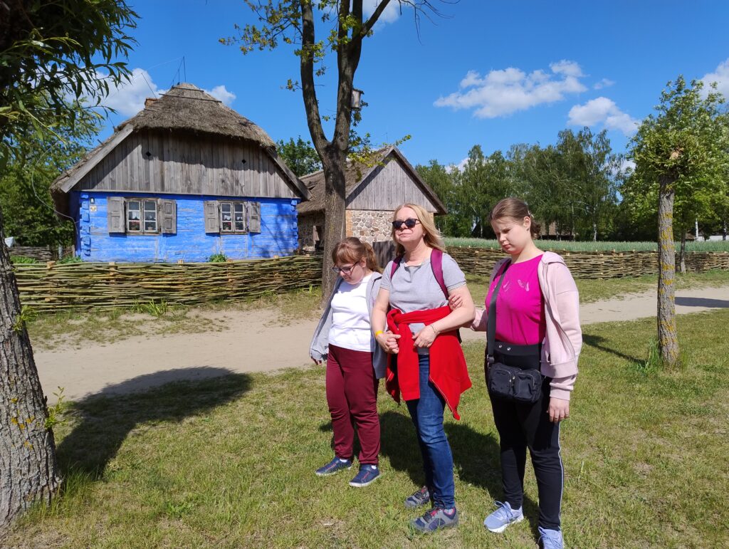 Ola, Konstancja i pani Beata stoją przed starą chatą