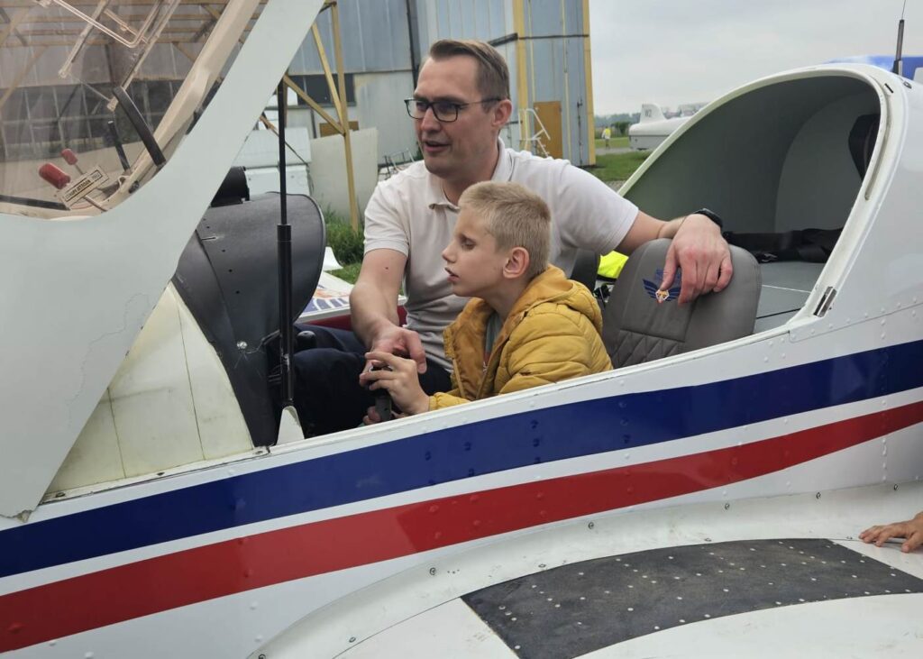 Chłopiec z pilotem w kabinie samolotu