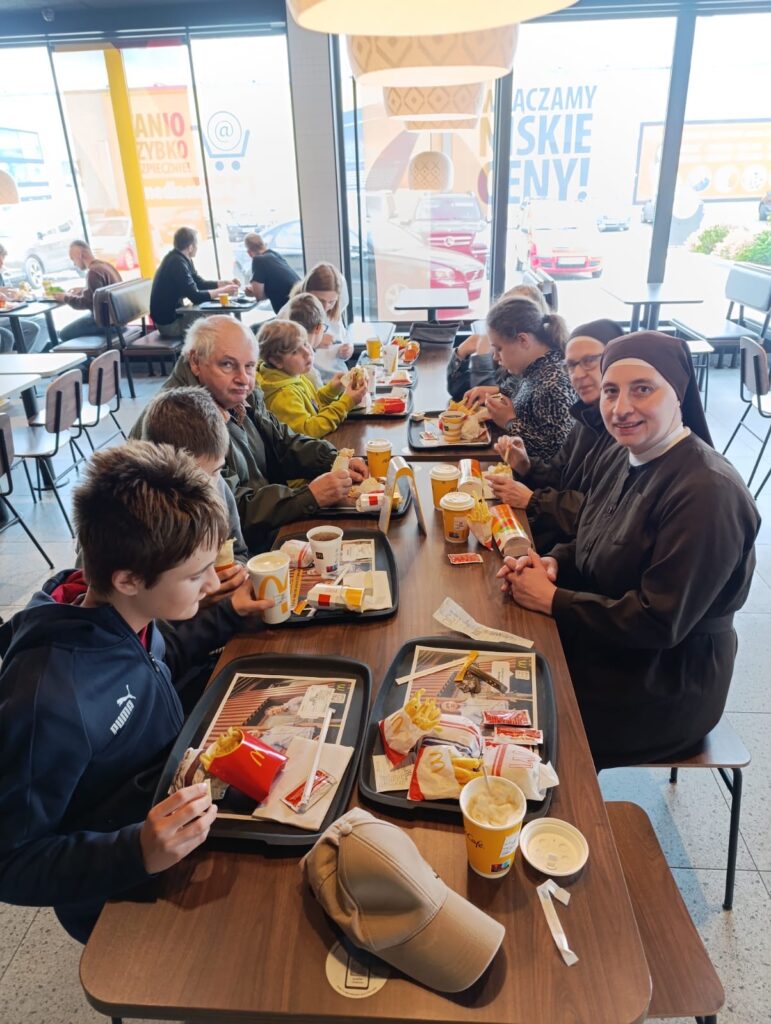 Uczestniczy wycieczki siedzący przy stole w restauracji McDonalds