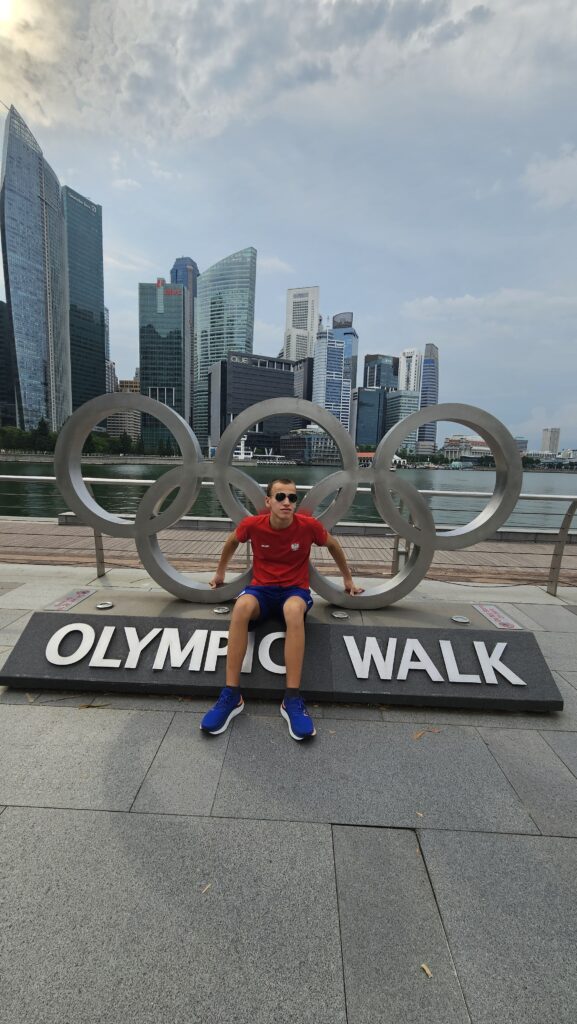 Alex przy pomniku w kształcie kół olimpijskich