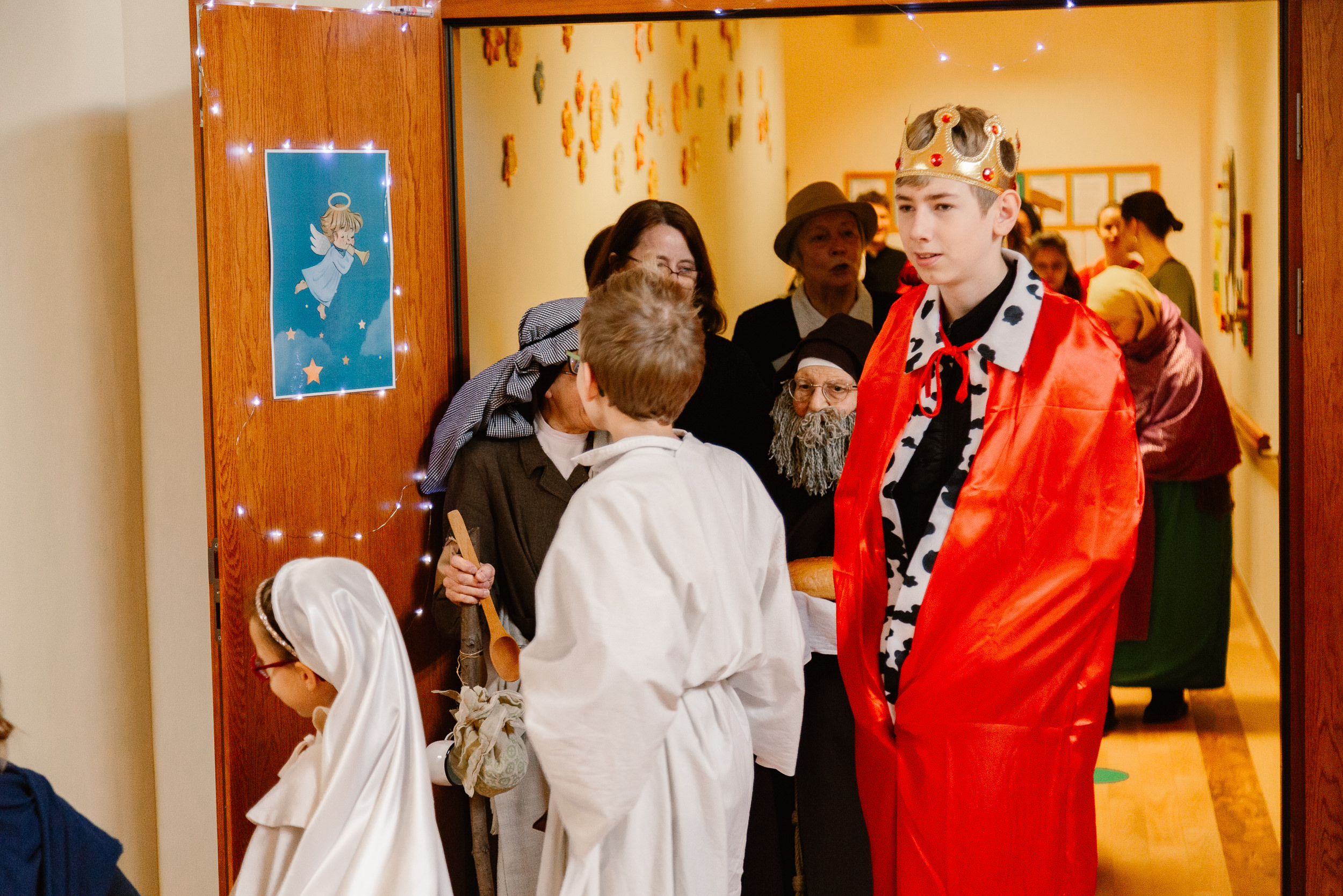 Uczniowie i nauczyciele w przebraniach świętych idą orszakiem po szkole