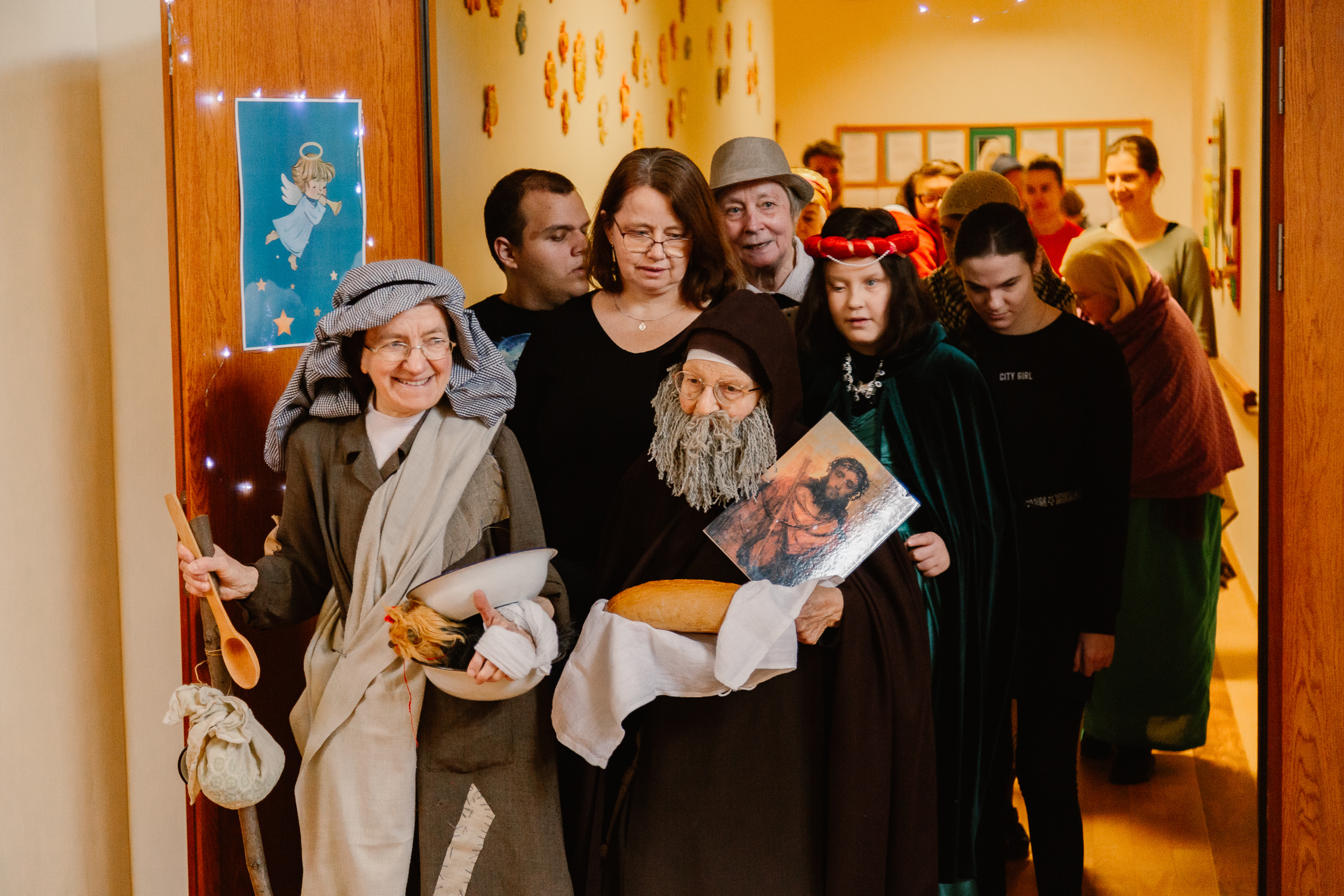 Uczniowie i nauczyciele w przebraniach świętych idą orszakiem po szkole