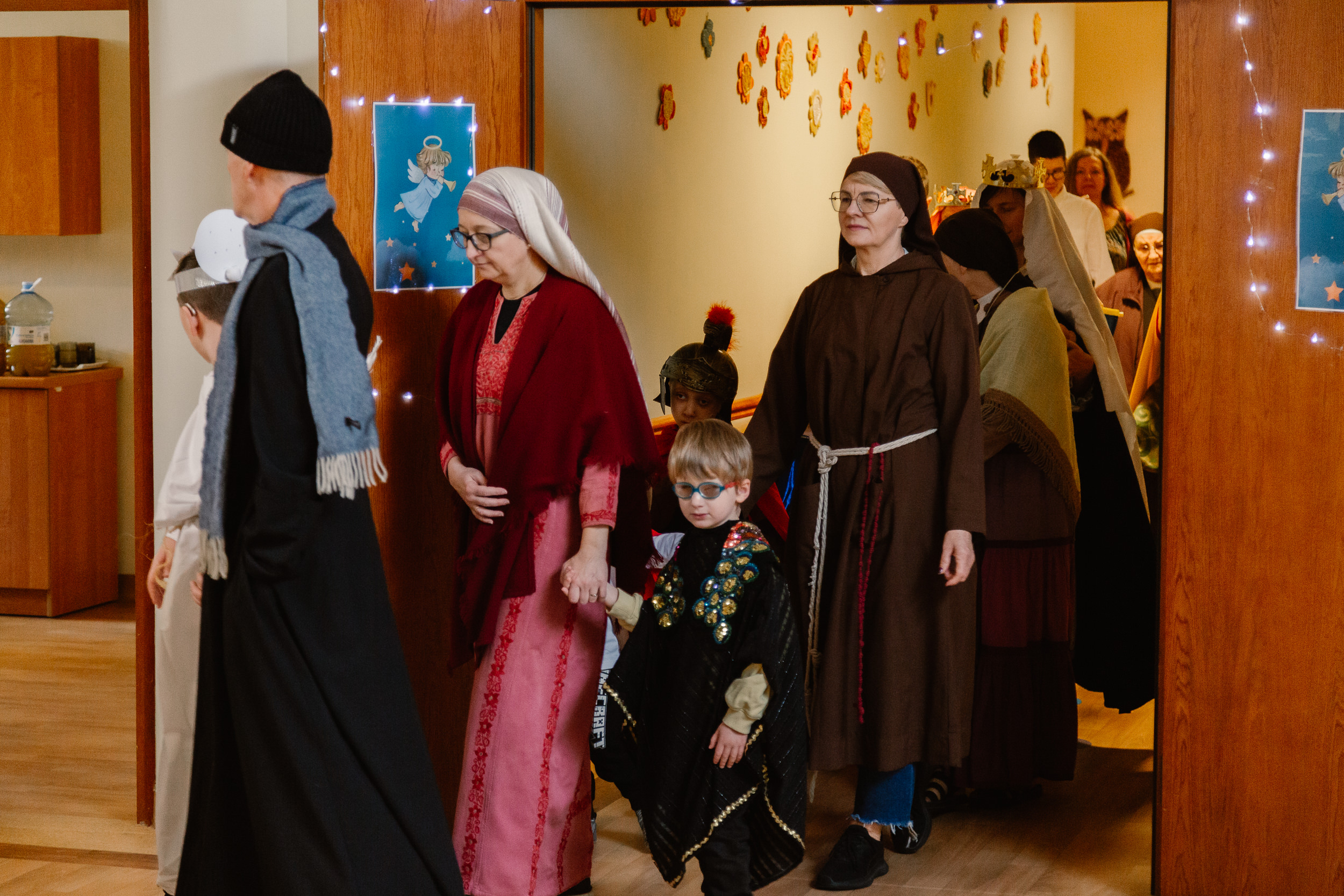 Uczniowie i nauczyciele w przebraniach świętych idą orszakiem po szkole