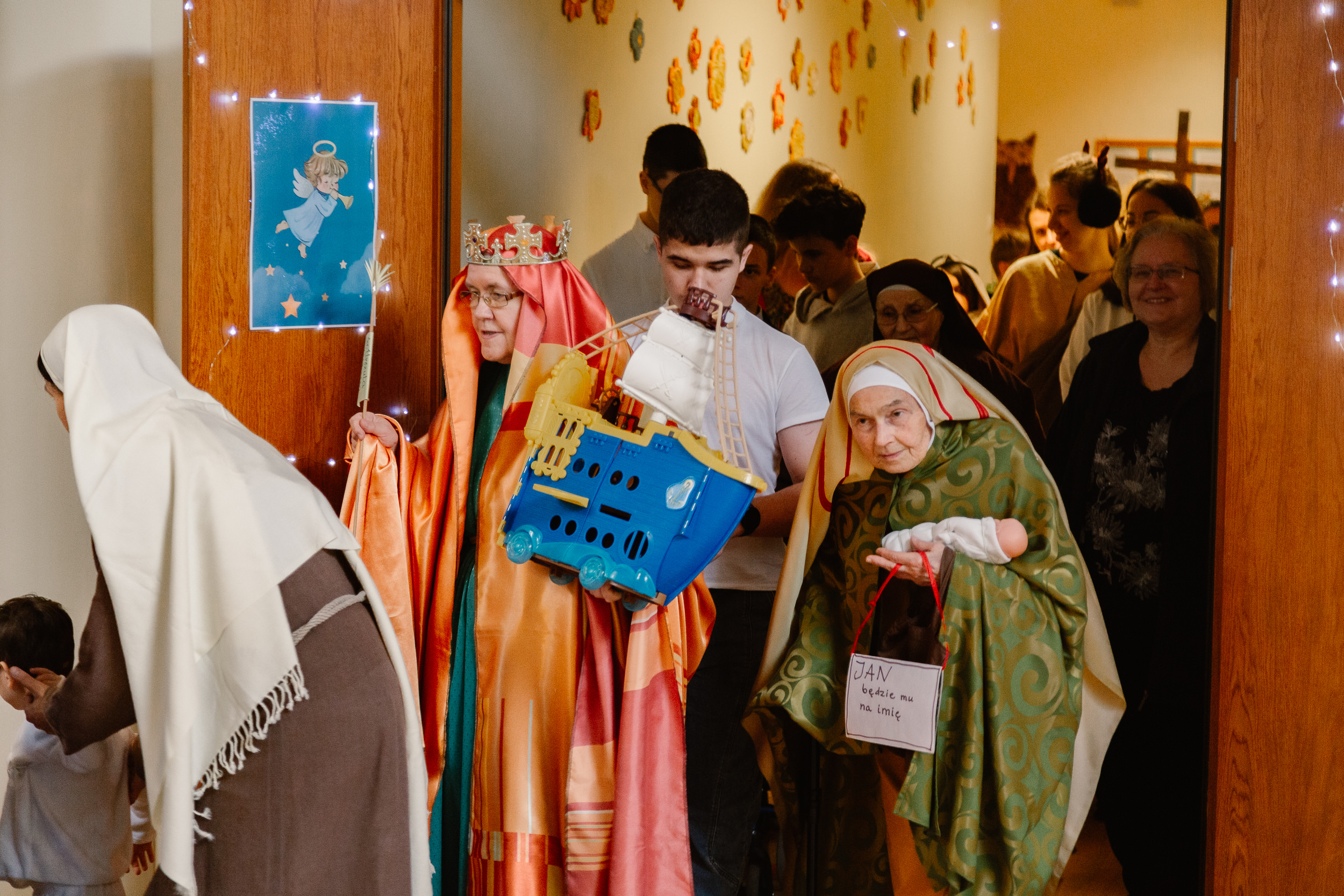 Uczniowie i nauczyciele w przebraniach świętych idą orszakiem po szkole