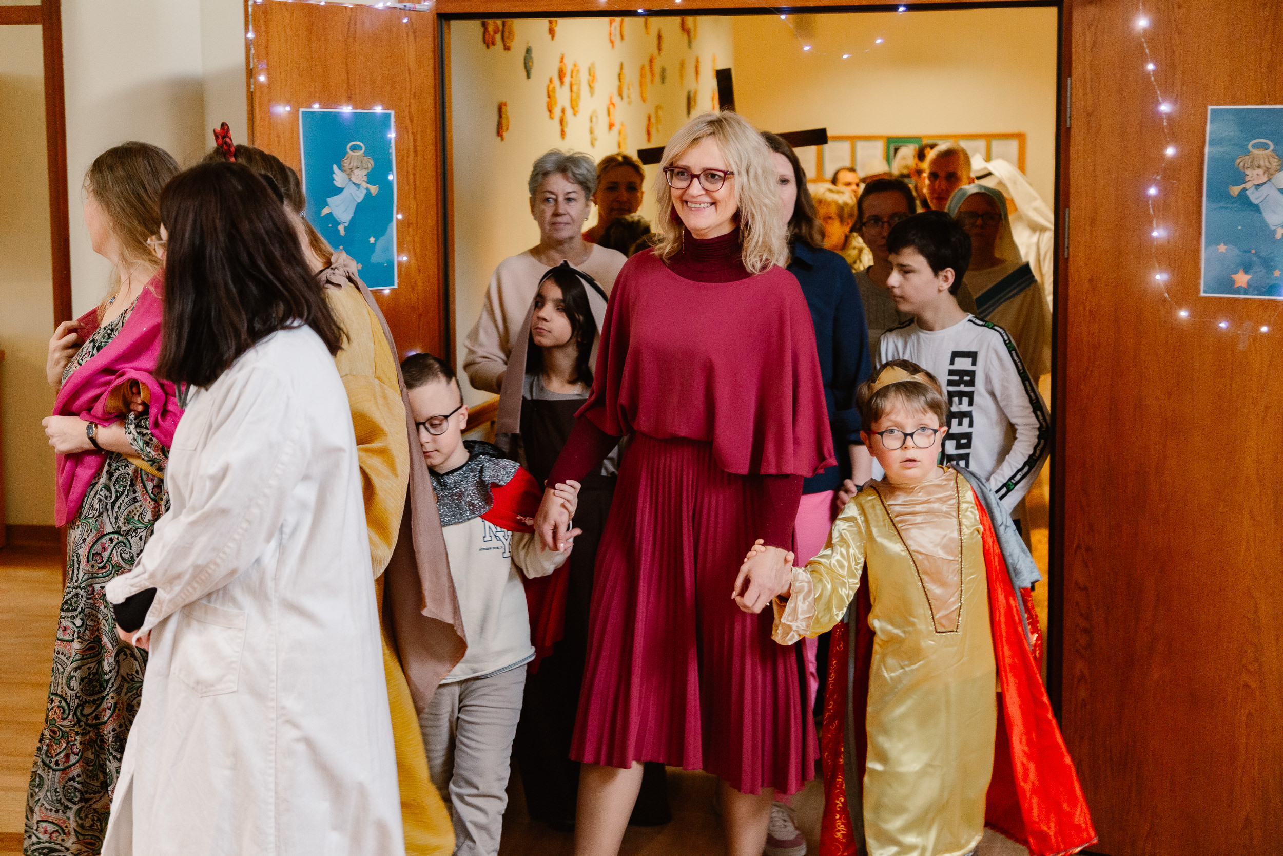 Uczniowie i nauczyciele w przebraniach świętych idą orszakiem po szkole