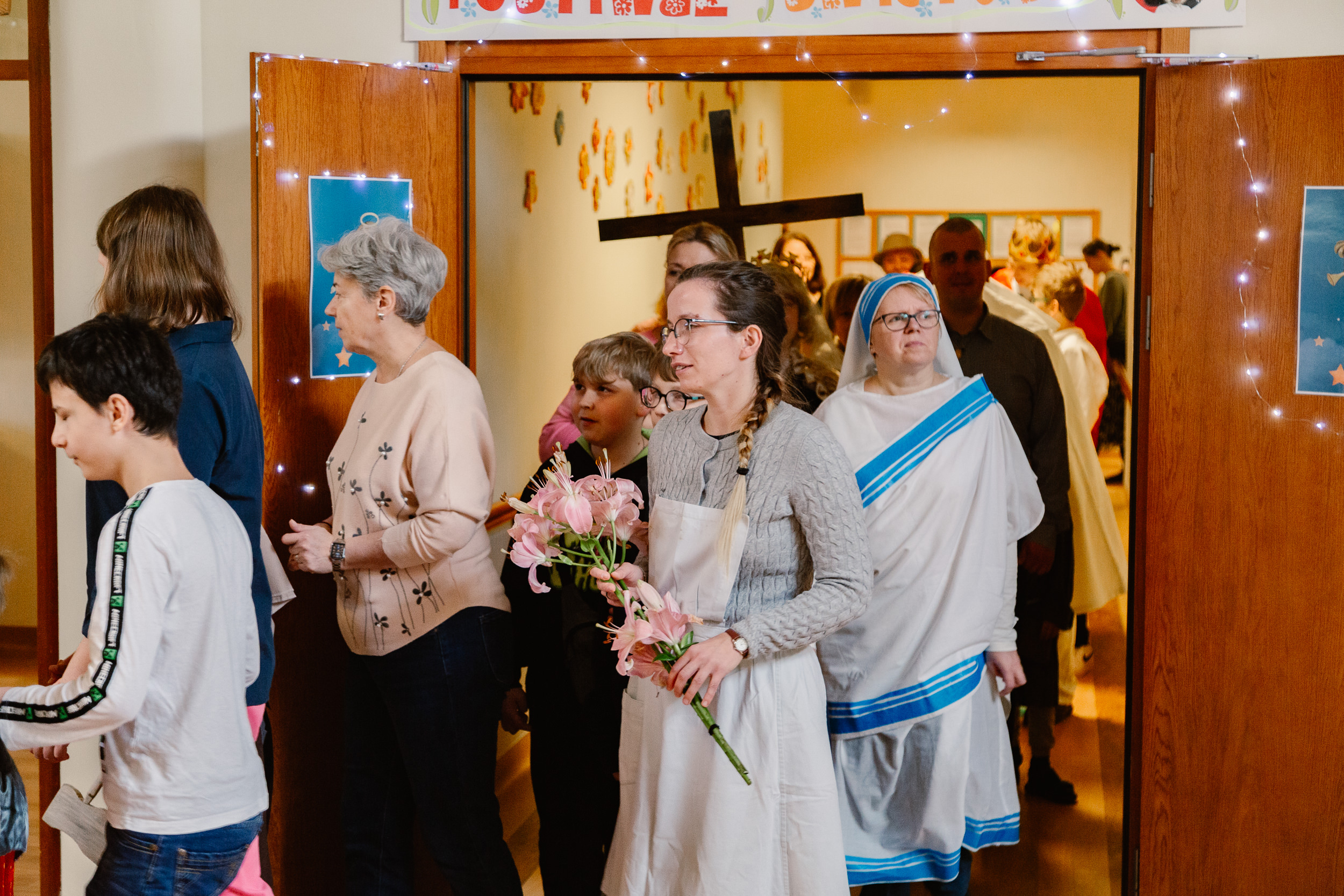 Uczniowie i nauczyciele w przebraniach świętych idą orszakiem po szkole