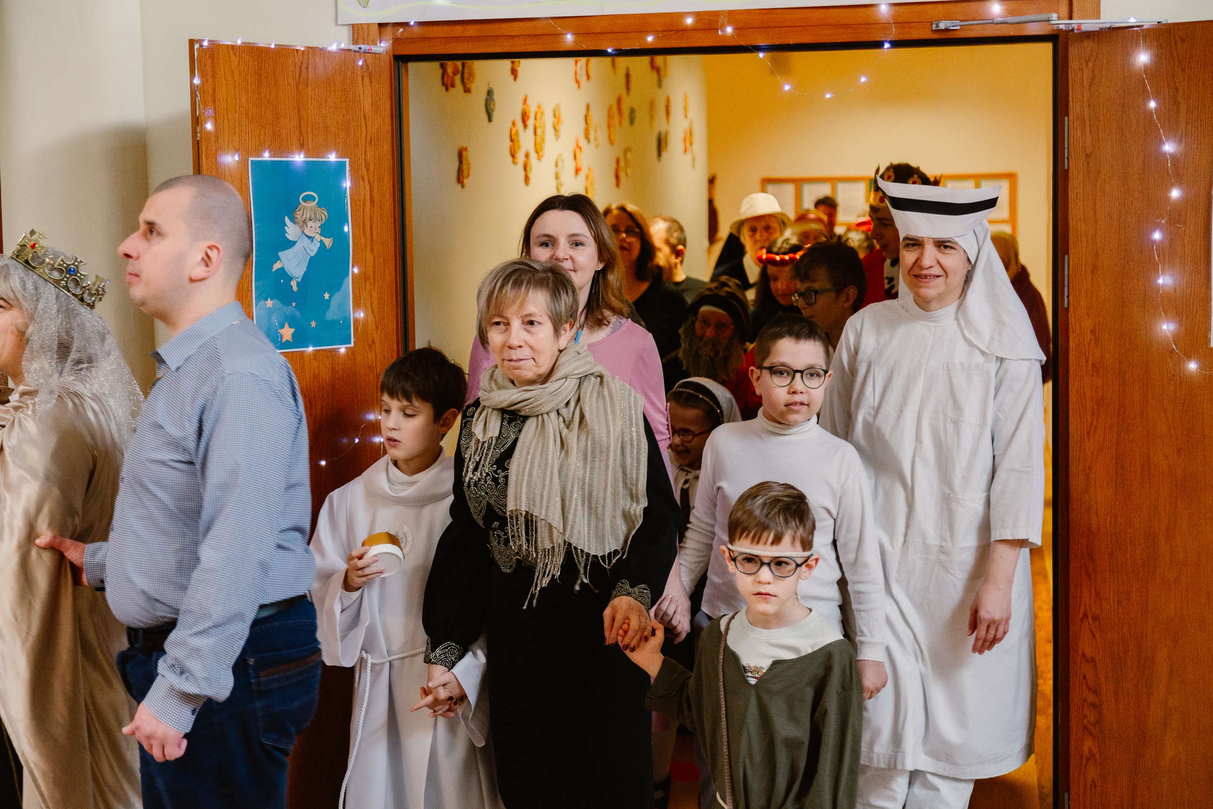 Uczniowie i nauczyciele w przebraniach świętych idą orszakiem po szkole