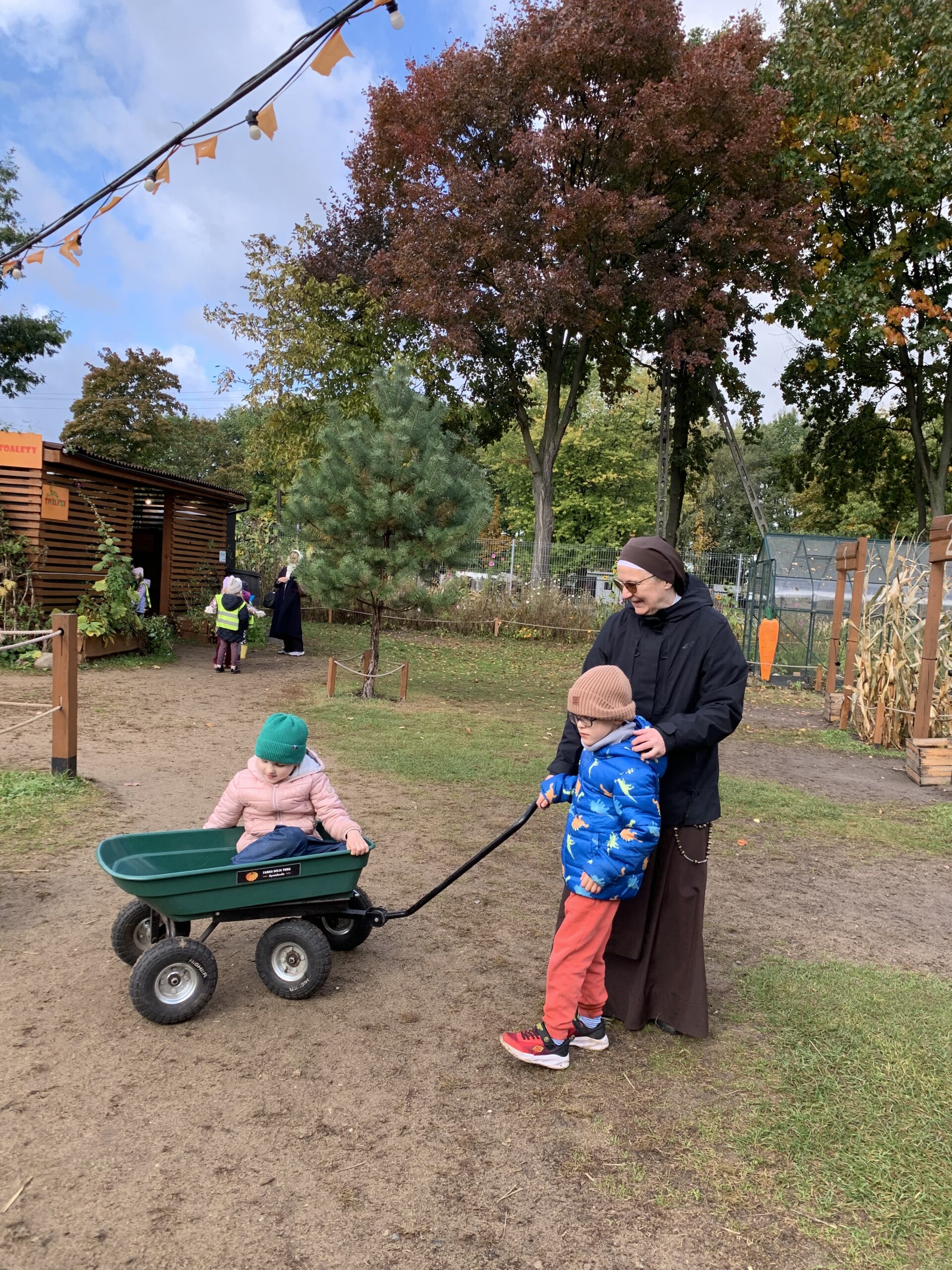 Uczeń z siostrą ciągną wózek, w którym siedzi dziewczynka