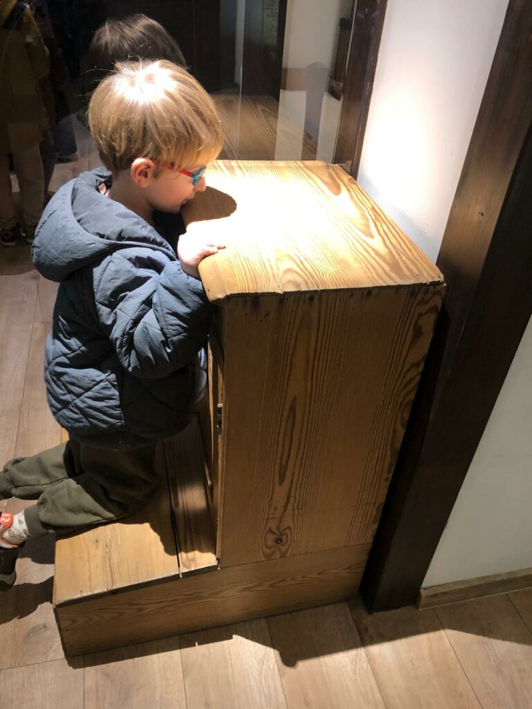 chłopczyk klęczy na klęczniku