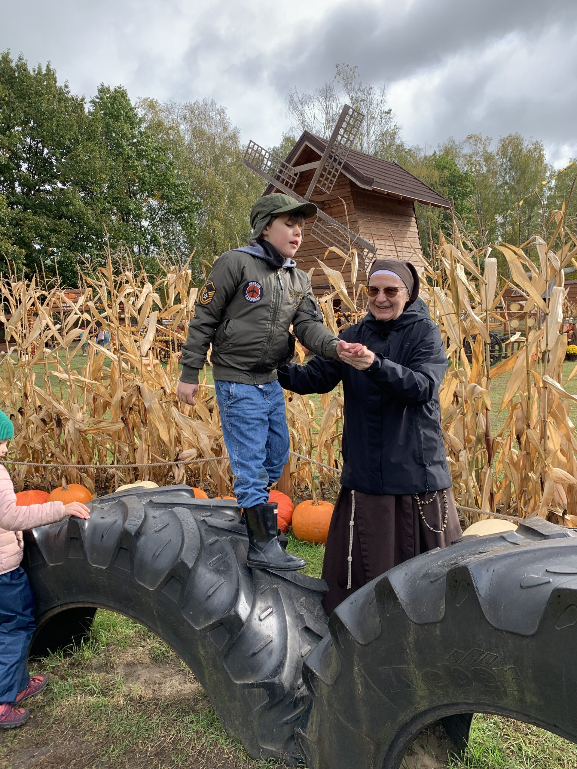 Chłopiec z pomocą siostry franciszkanki chodzi po oponach