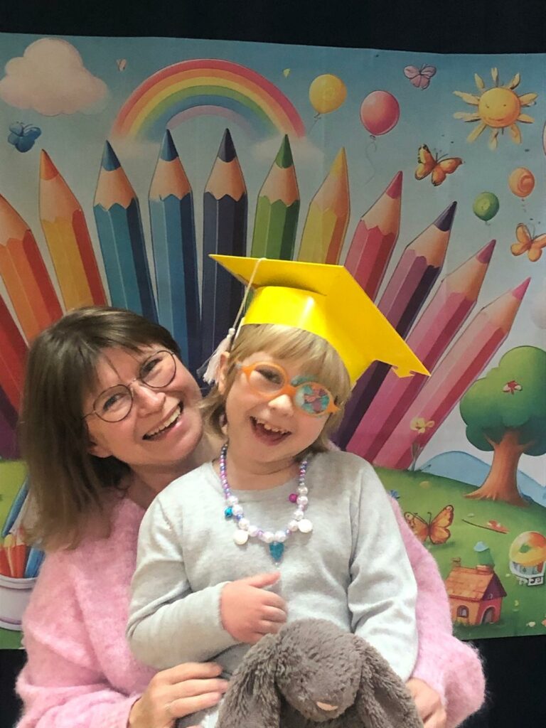 Mama z córką w birecie na tle dekoracji.