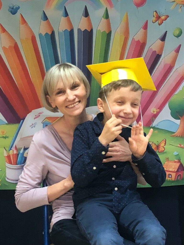 Uśmiechnięci mama z synkiem na tle dekoracji.
