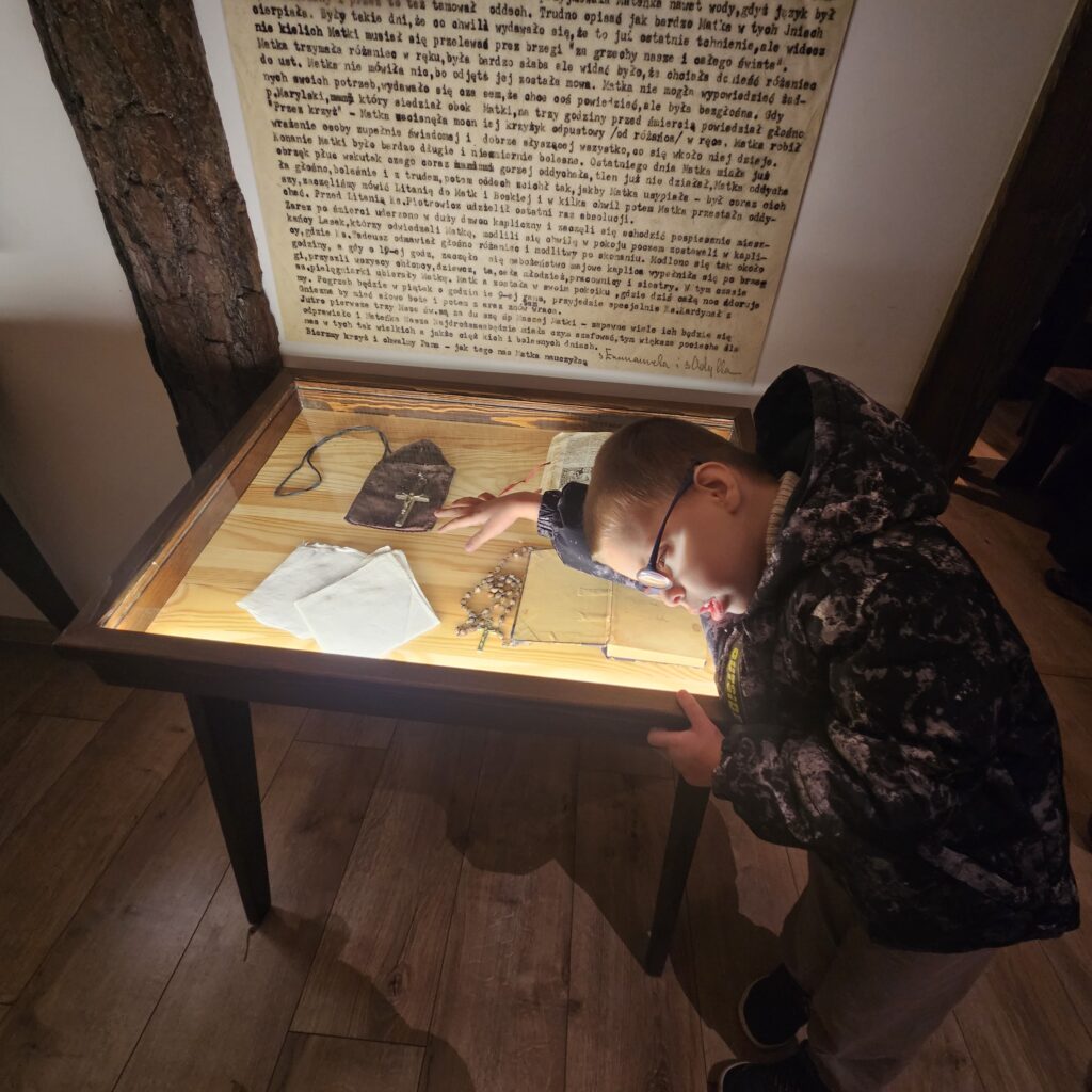 mały chłopiec ogląda w gablocie relikwie Matki Róży