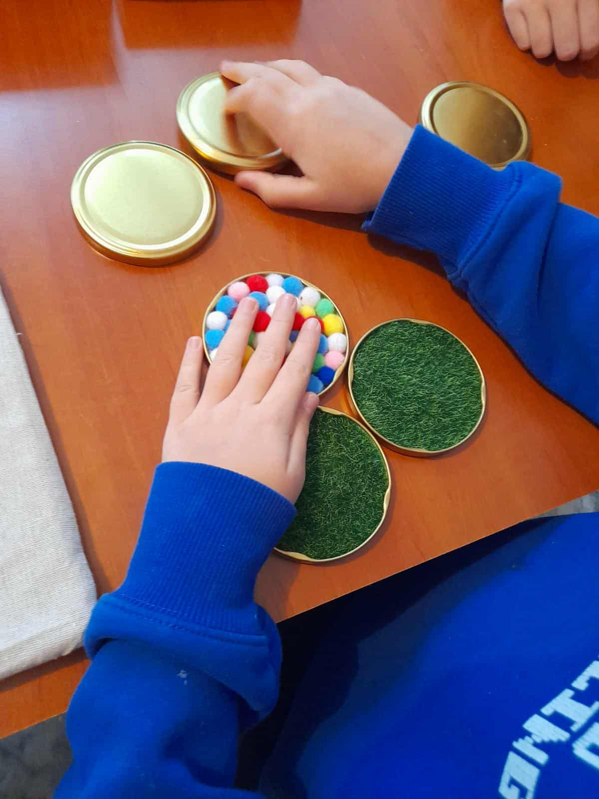 Dziecięce dłonie oglądają pomoce tyflopedagogiczne