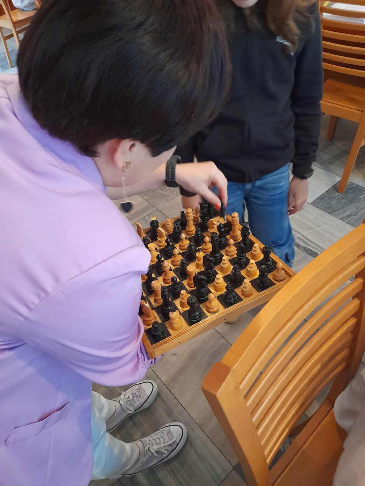 Uczniowie oglądają szachy dla osób niewidomych