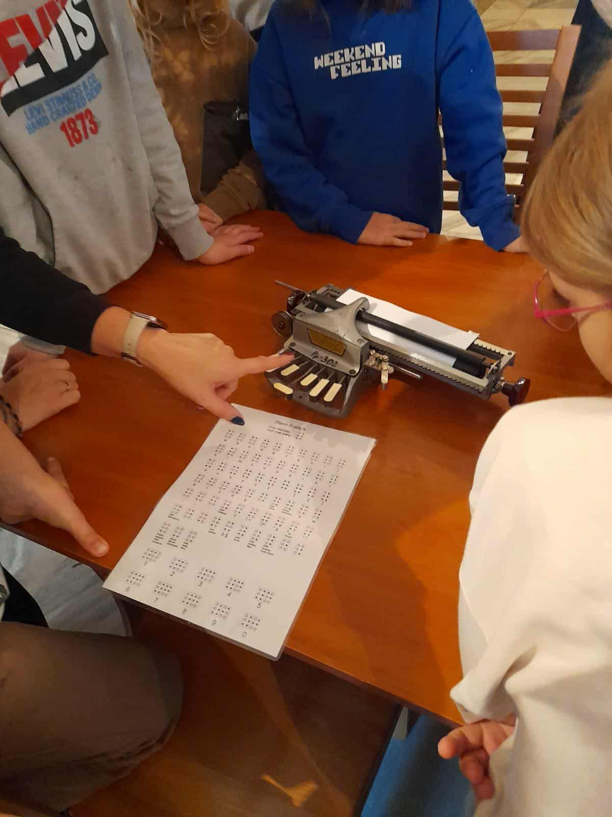 Uczniowie oglądają maszynę brajlowską