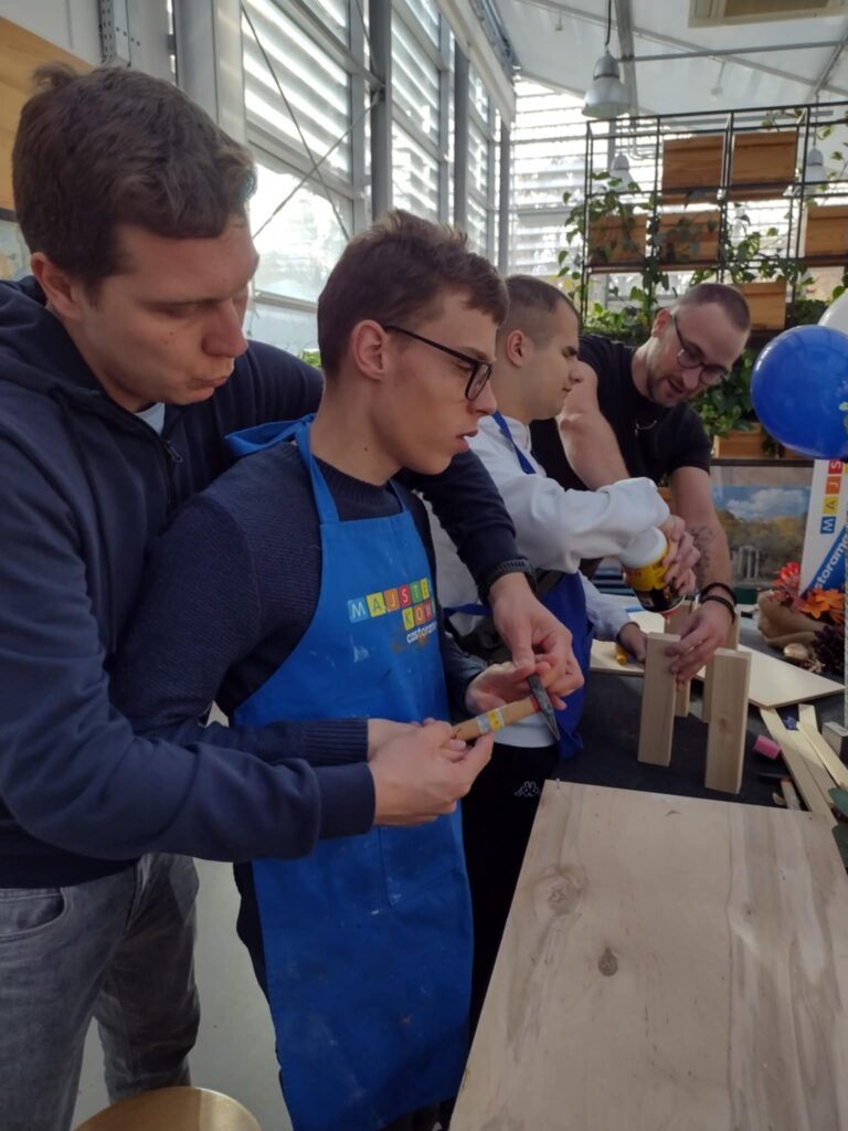 Na zdjęciu uczeń z pomocą nauczyciela sprawdza działanie młotka.