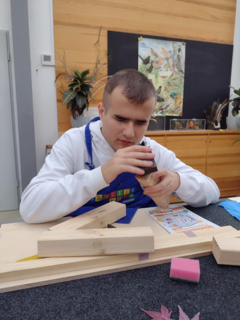 Na zdjęciu uczeń ustawia drewniane klocki.