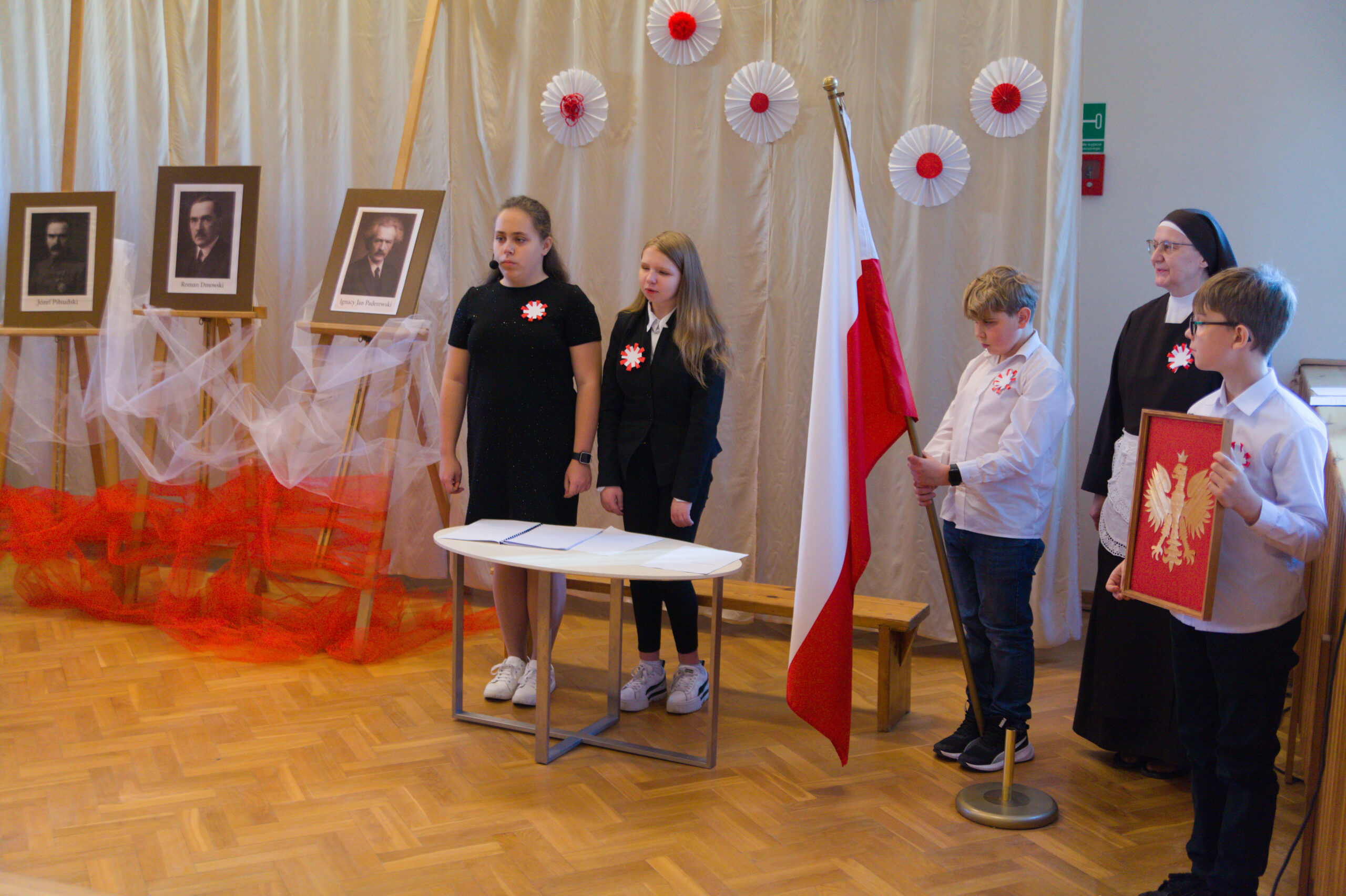 Uczniowie śpiewają hymn stojąc na baczność