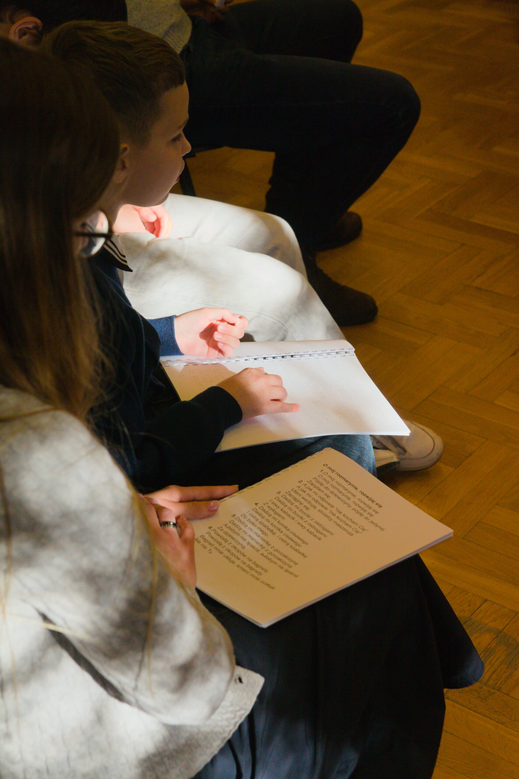 Uczniowie czytają pieśni pismem brajla