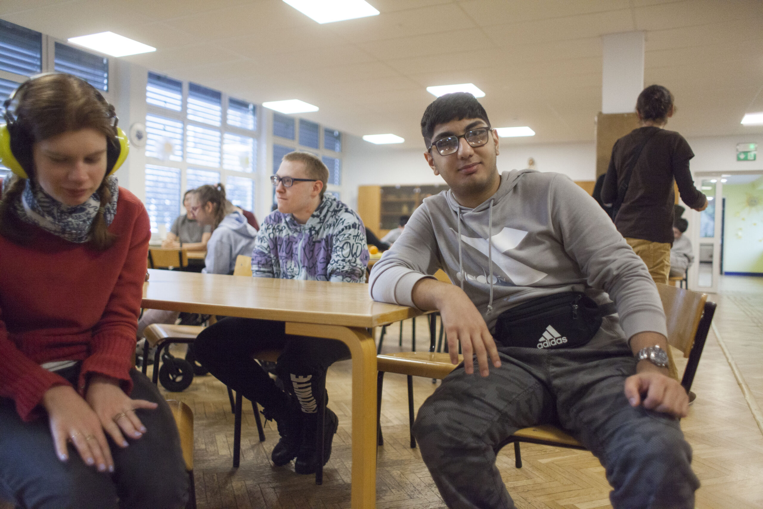 Uczniowie siedzący przy ławce.