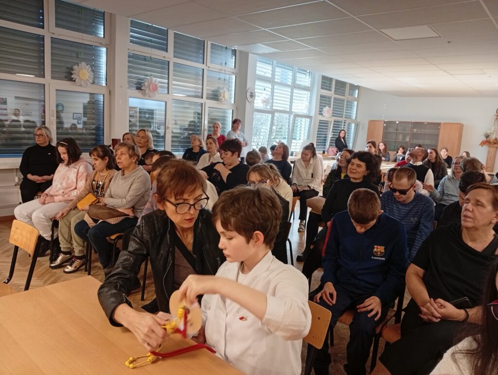 Widzowie siedzą na krzesłach