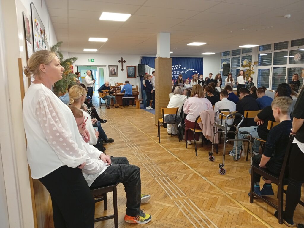 Widzowie siedzą na krzesłach