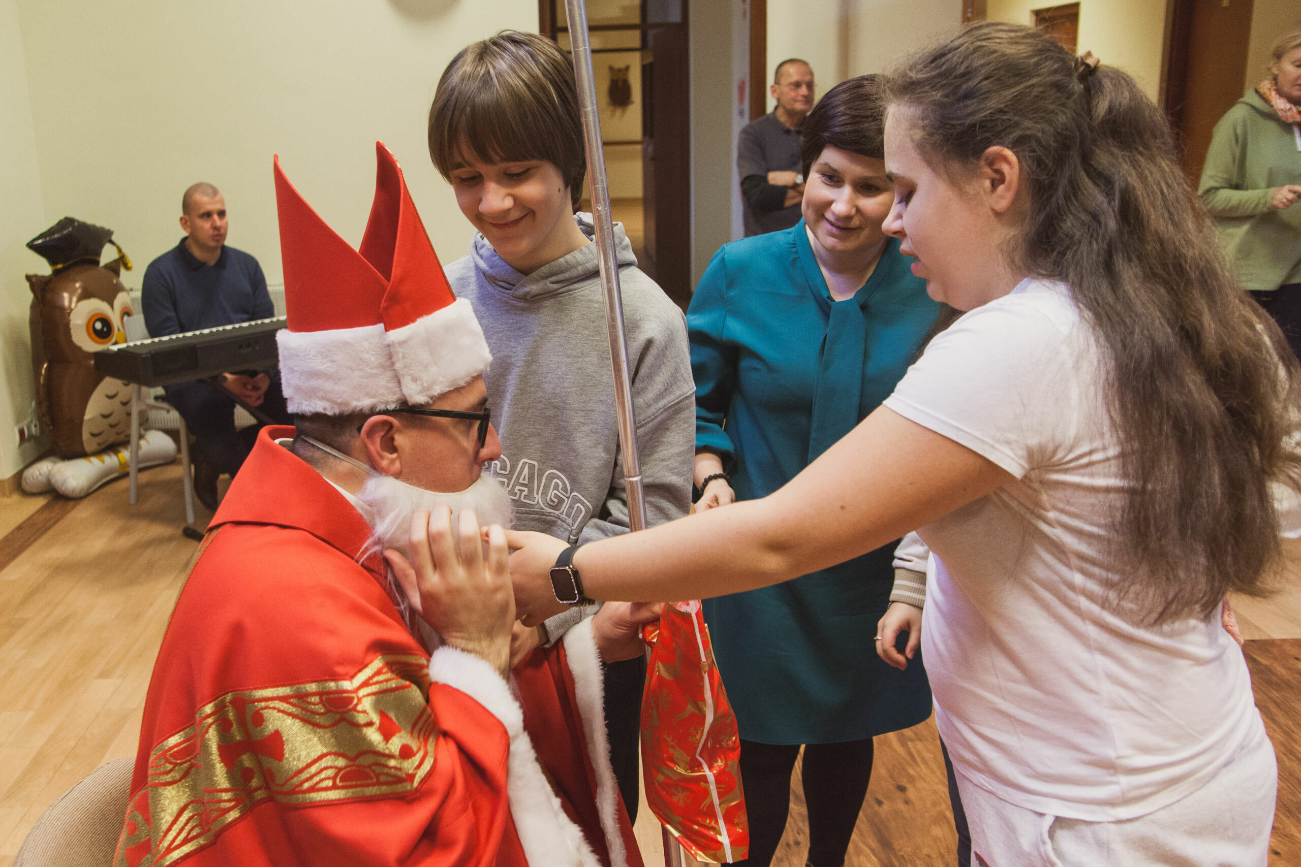 Dzieci dotykają brody Mikołaja.