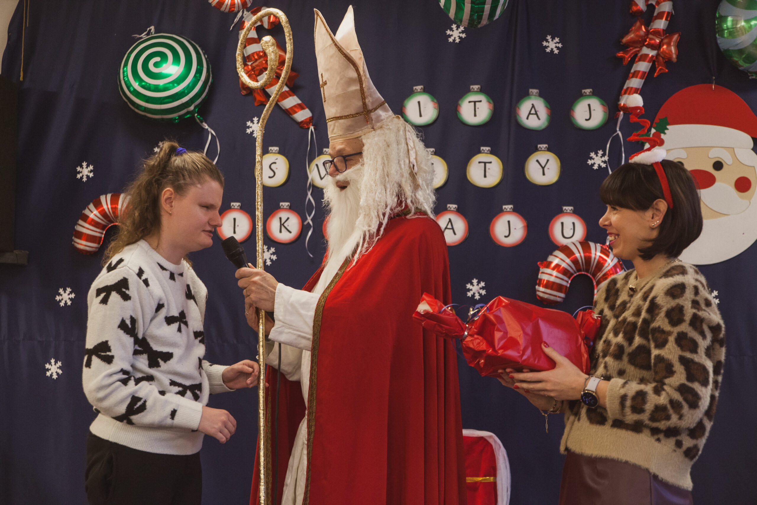 Mikołaj wręcza prezenty uczniom.