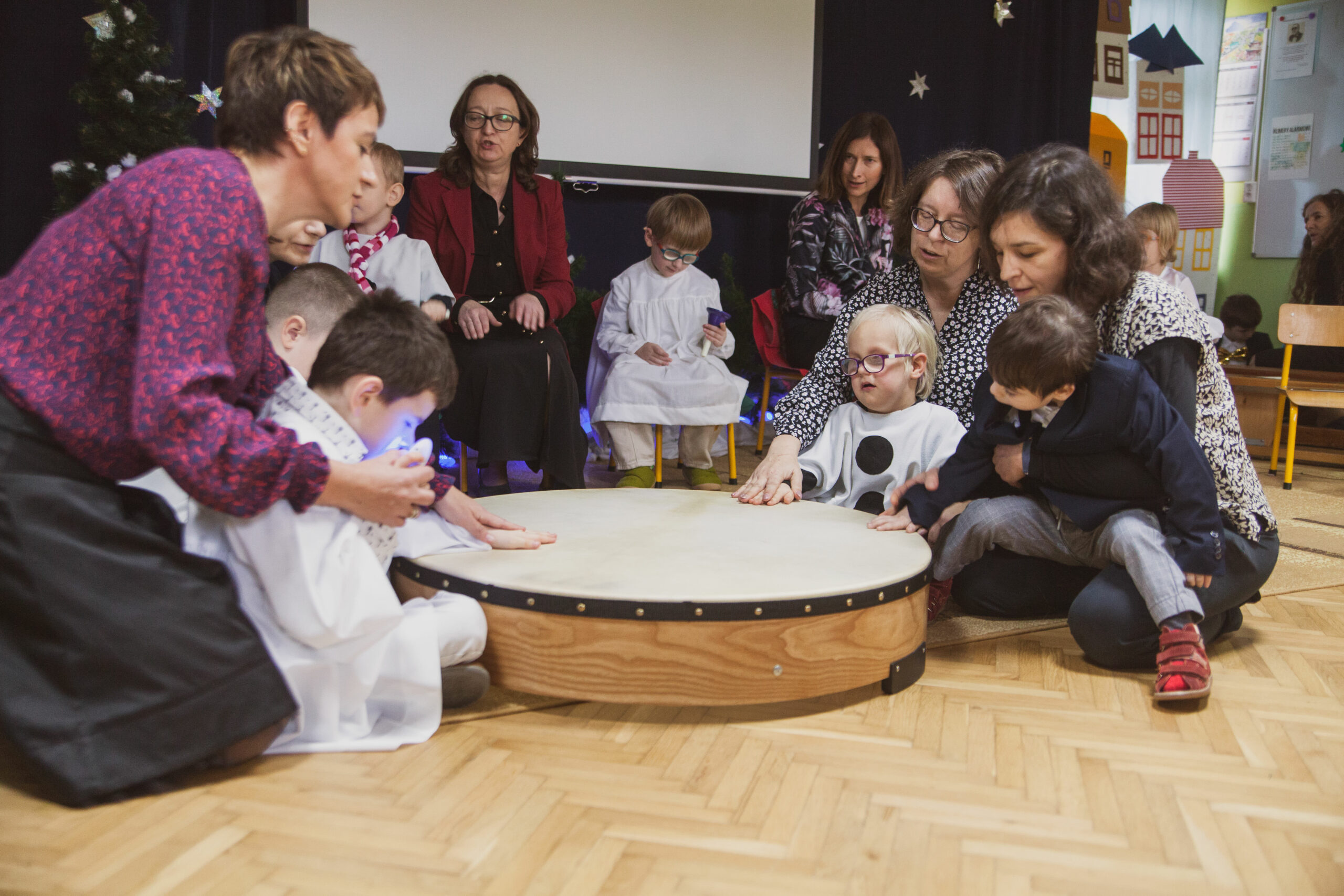 Przedszkolaki grają na wielkim bębnie.